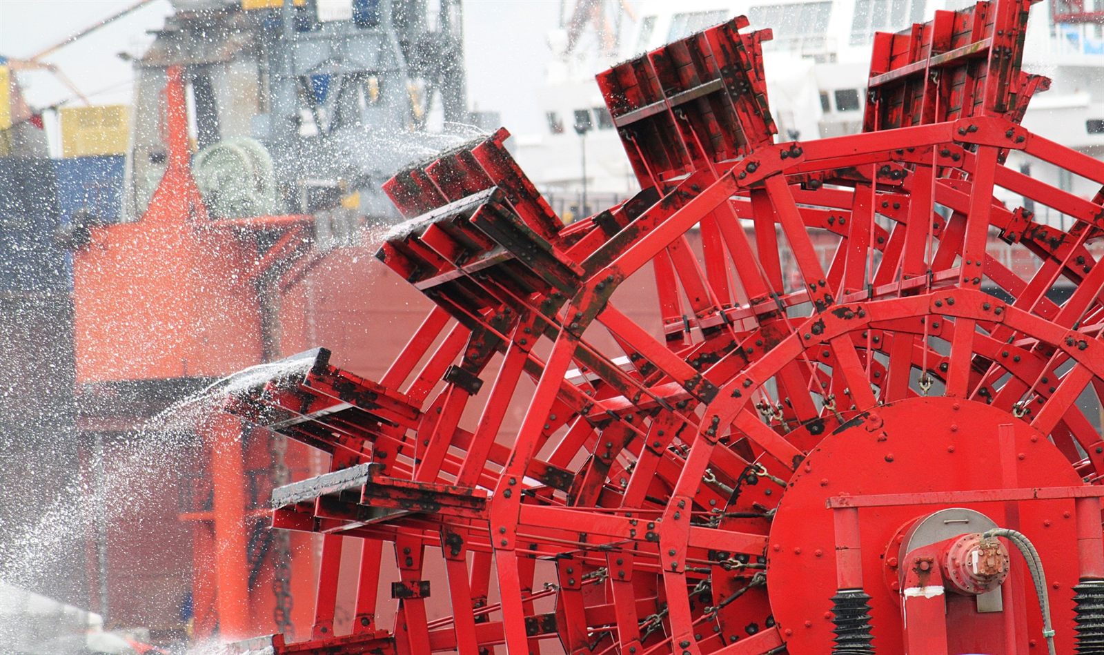 Red stern paddlewheel throwing off spray, the signature of sternwheeler cruises