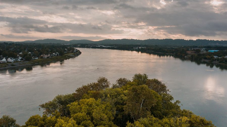 Tennessee River flowing between autumn trees at sundown
